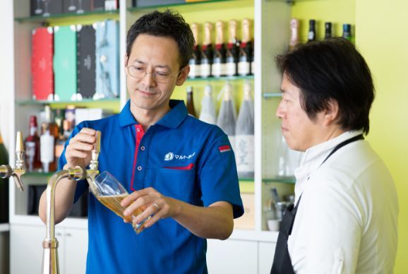 飲食店にビールの注ぎ方を指導しているマルト水谷の営業員