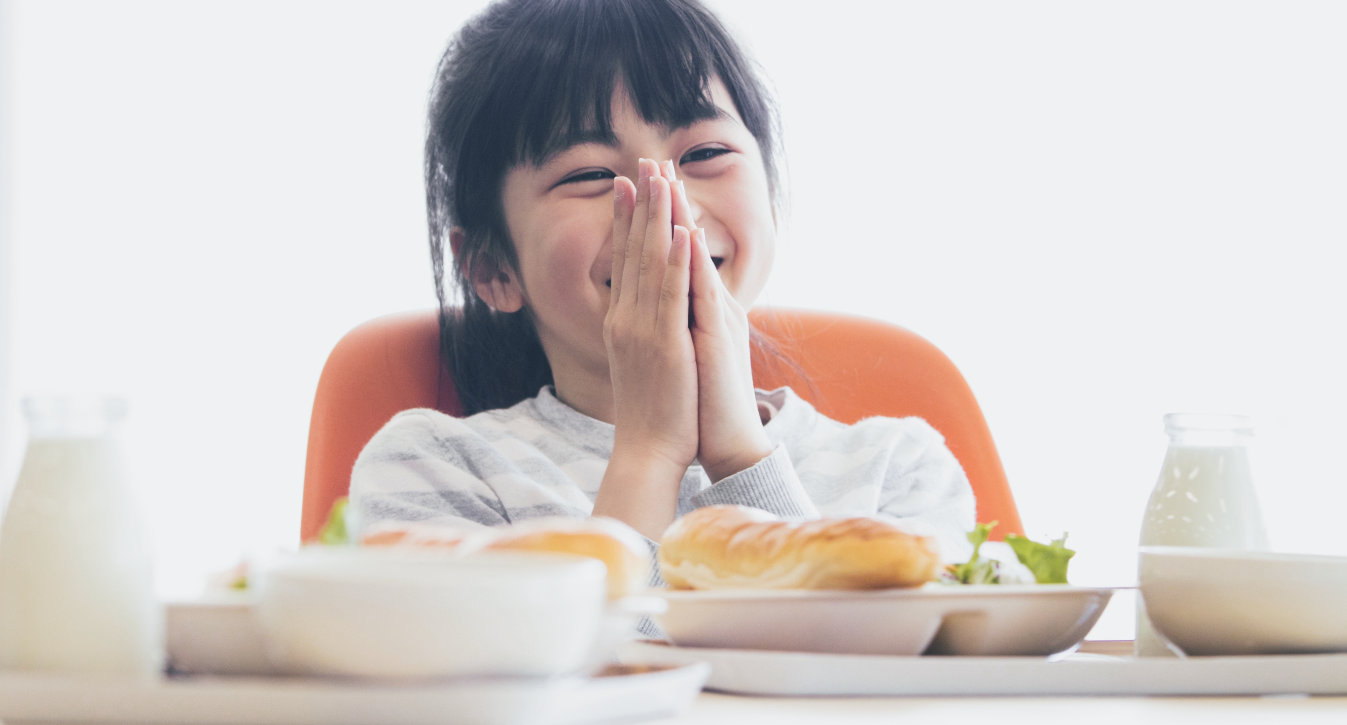 両手を合わせていただきますをしている女の子の写真
