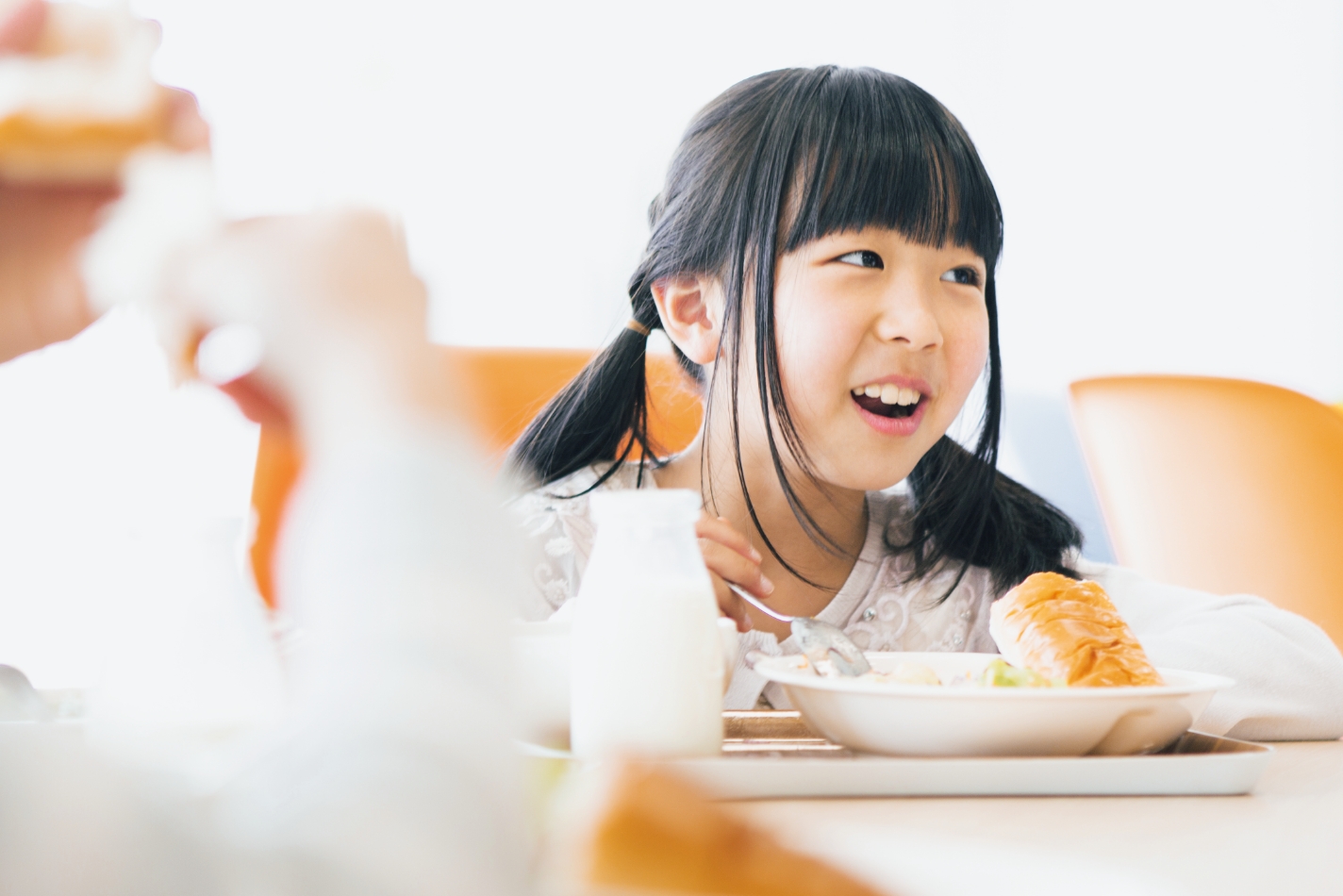 女の子が楽しそうに食事をしている写真